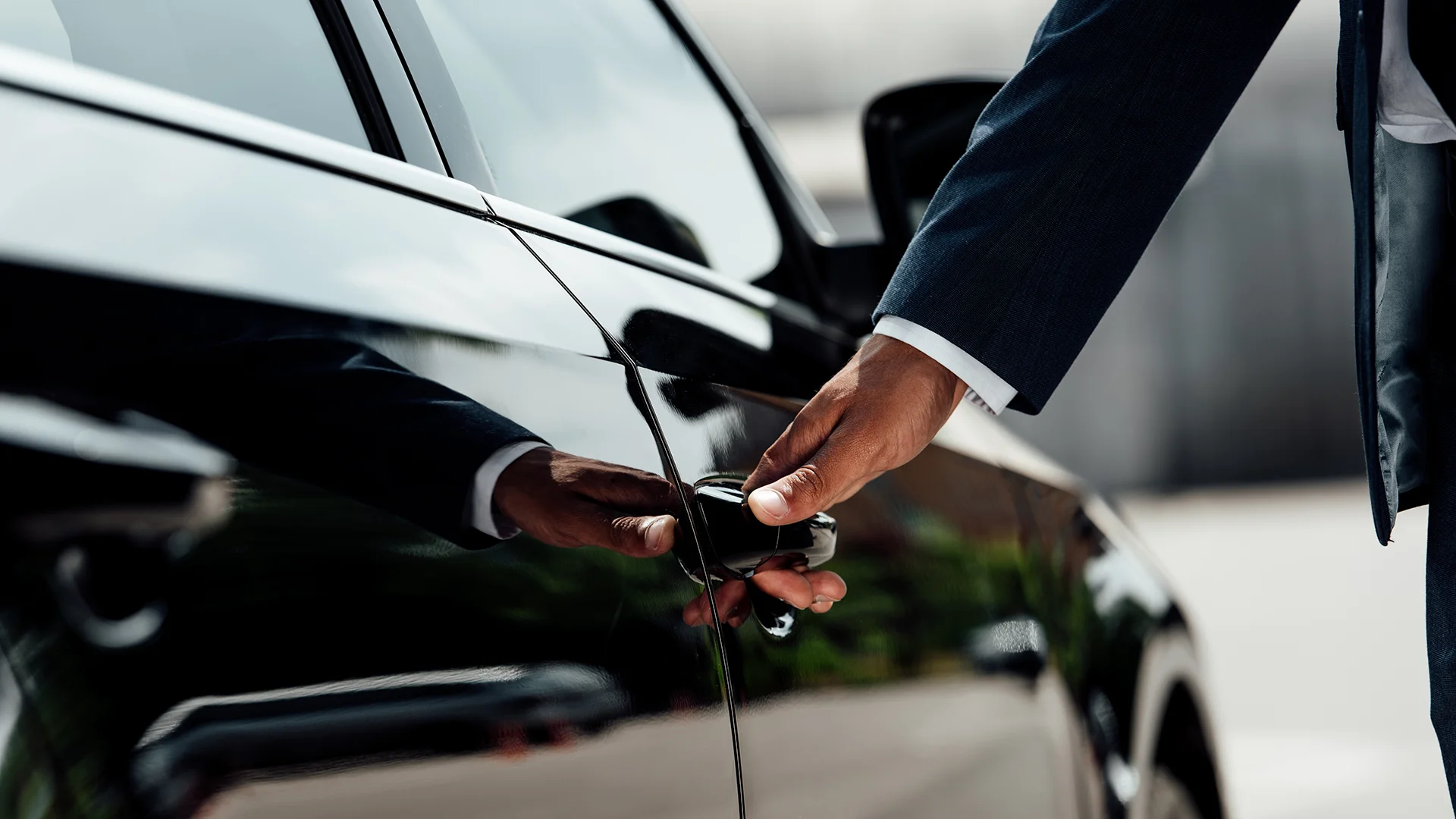 cropped view of chauffeur in opening the door of a car