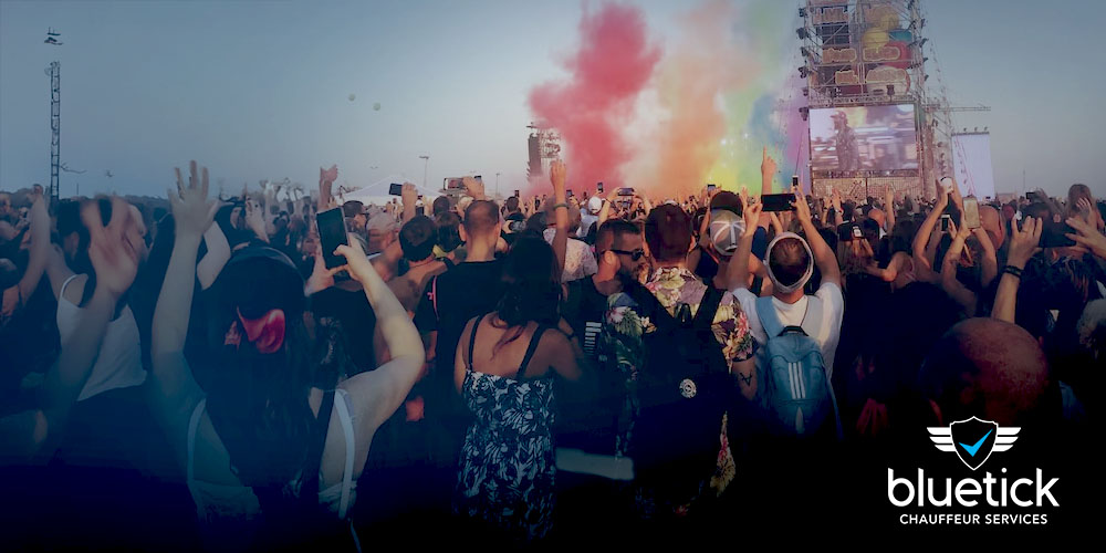 Festival-goers dancing and celebrating in front of the Pyramid Stage at Glastonbury, surrounded by flags, music, and a vibrant crowd.