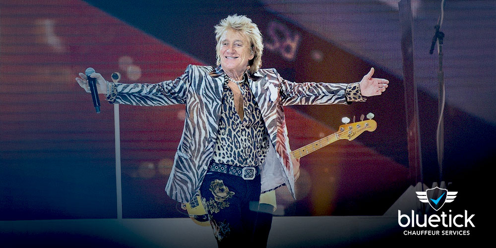 Rod Stewart performing live on stage under dramatic lighting, captivating the Glastonbury crowd.